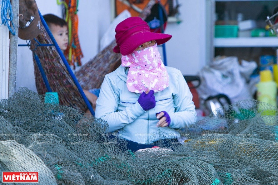 Des pêcheurs raccommodent un filet pour préparer à une nouvelle saison de pêche. Photo : VNP