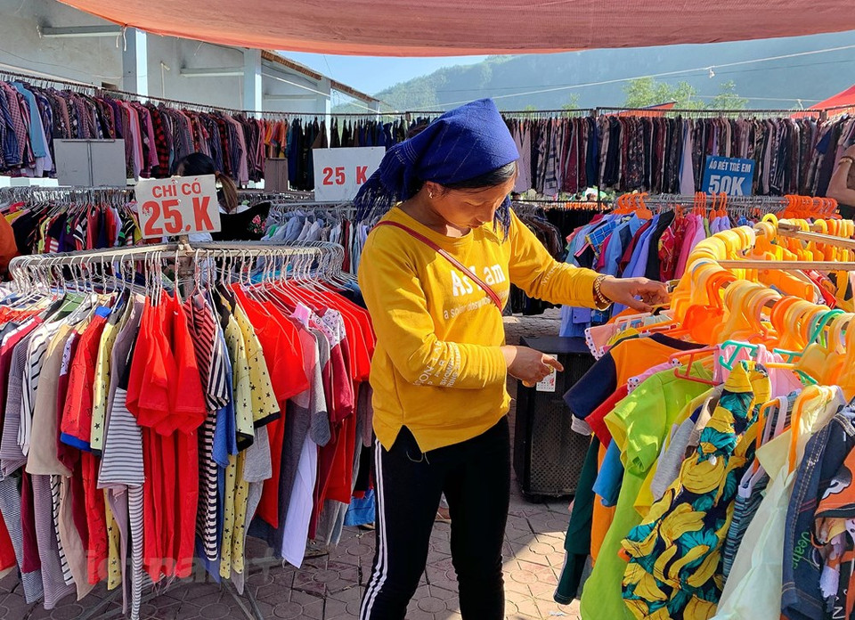 Les habitants, revêtus de costumes et de robes colorés, affluent au marché d'Y Ty, dès le petit matin. Ils sont ravis de pouvoir choisir de nouveaux vêtements et de nouvelles chaussures. Ce sont les stands de vêtements, de bijoux, de chaussures qui attirent le plus de clients, car tout le monde veut être beau. Les filles issues de l'ethnie Hà Nhi essaient avec enthousiasme des vêtements et des robes aux couleurs vives auxquels sont attachées des pièces d'argent brillant émettant des tintements à chaque mouvement. Les mères et des filles profitent de cette occasion pour acheter de beaux vêtements pour leurs enfants ou pour elles-mêmes. Photo: VietnamPlus