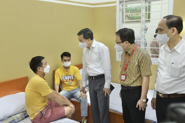 Le vice-ministre de la Santé, Trân Van Thuân, encourage des volontaires avant l’injection. Photo : VNA 