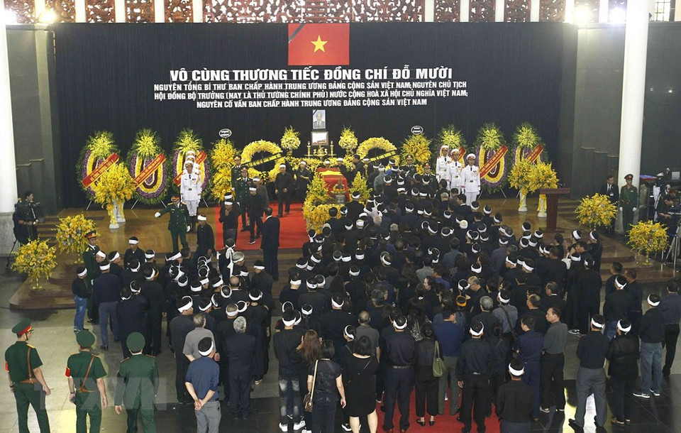 La famille et les proches font le tour du cercueil.