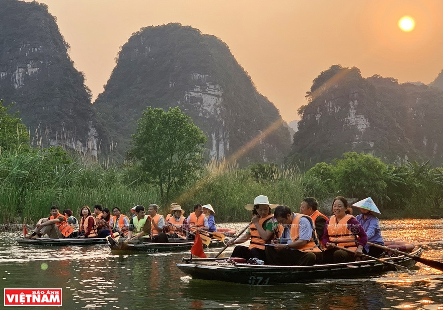 Des touristes étrangers visitent le complexe paysager de Trang An, Ninh Binh