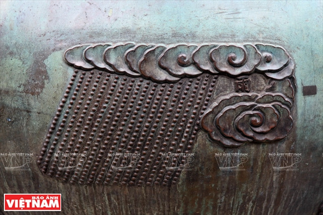 Le symbole de la pluie abondante, sur l'urne Huyên. Selon le Yi Jing (également orthographié Yi King ou Yi-King), manuel classique chinois dont le titre peut se traduire par «Classique des changements» ou «Traité canonique des mutations»), la pluie appartient au lot Kham, symbolisant l'eau.