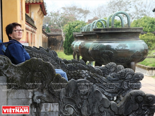 Une touriste assise sur les marches du pavillon Hiên Lâm.