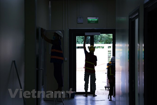 La construction de l'hôpital n'utilise pas les fonds du budget de l'État. Notamment, Sun Group a financé les travaux à hauteur de 100 milliards dôngs. Les mesures de prévention et de protection ont été sérieusement mises en œuvre pour tous les ingénieurs et ouvriers travaillant sur ce chantier. Ils doivent se faire contrôler la température corporelle, avant leur entrée et se conformer au message dit "5K" (sigles vietnamiens de Khâu trang (Masque), Khu khuân (Désinfection), Khoang cach (Distanciation physique), Không tu tâp (Pas de rassemblement) et Khai bao y tê (Déclaration médicale) ; être testés pour le dépistage du SARS-CoV-2... Le test doit être effectué chaque semaine pour tous les travailleurs. Photo: VietnamPlus