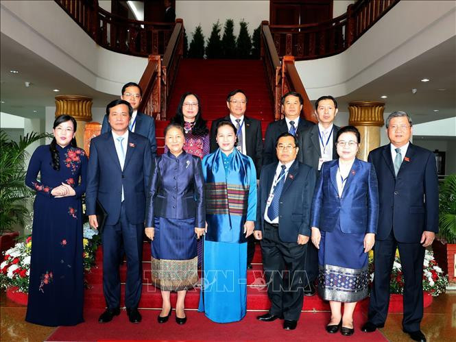Les deux présidentes des AN du Vietnam et du Laos, et des délégués posent une photo en groupe. Photo: VNA