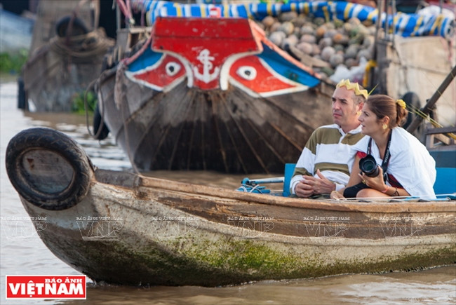 Touristes étrangers visitant le marché flottant Caï Rang.