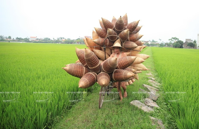 M. Bac transportant chaque jour des nasses sur son vélo pour les vendre dans les villages voisins.