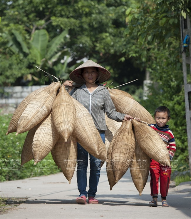 Mère et enfant apportant des nasses à vendre au marché. 