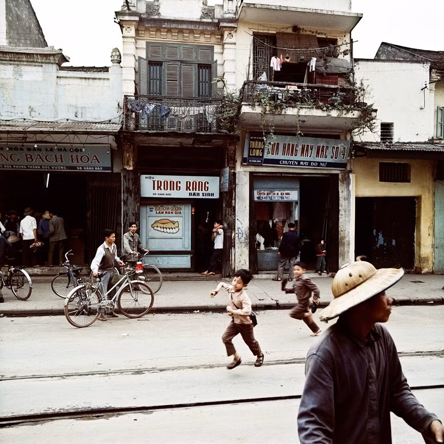 Hang Dao - rue des teinturiers de la soie rouge en 1975. Situé au centre-ville, Hang Dao, d’une longueur de 260 mètres, était célèbre pour ses magasins vendant de la soie et accueillait une ligne de tramway allant du lac Hoan Kiem (Épée restituée) au jardin Hang Dau. C'était la rue principale et caractéristique des 36 rues et corporations à Hanoï. La rue des teinturiers de la soie rouge s’est établie dès le XVe siècle. Hang Dao signifie littéralement la rue où l’on vend des tissus teints en rouge. En effet, dès les XIVe-XVe siècles, les villageois, originaires essentiellement de Dan Loan, province de Hai Duong (Nord), sont venus s’y installer pour exercer leur métier de teinturerie. Photo: Vietnamplus