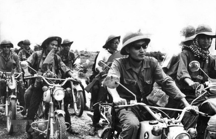 Des reporters de l'Agence vietnamienne d’Information et leurs collègues de l'Agence d'information de Libération devant la porte de Saigon au matin du 30 avril 1975.