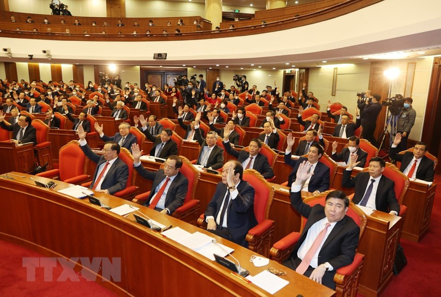  Des dirigeants du Parti, de l’Etat et des délégués votent pour approuver l’agenda du 14e Plénum du CC du Parti. 