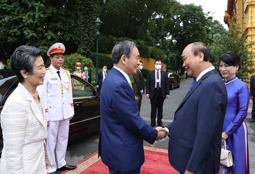  Le Premier ministre Nguyen Xuan Phuc (droite) et son épouse à la cérémonie d’accueil en l'honneur du Premier ministre japonais Suga Yoshihide et de son épouse.