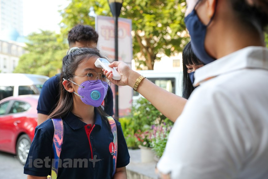  Après deux mois de vacances, avec près de 23 millions d’élèves dans l’ensemble du pays, plus de 2,1 millions d’élèves de Hanoï ont entamé le matin du 5 septembre une nouvelle année scolaire 2020-2021. À l’école Marie Curie Hanoi, tous les élèves doivent respecter les règles sanitaires pour prévenir l’épidémie du COVID-19. Élèves, enseignants et invités étaient tenus de porter un masque et d’utiliser du gel hydroalcoolique après contrôle de leur température. Les établissements d'enseignement préscolaire ont organisé leur cérémonie d'ouverture guidés par la devise ''Les enfants vont à l’école avec enthousiaste'' de manière créative, tout en respectant les principes de distanciation sociale. Photo : Vietnamplus