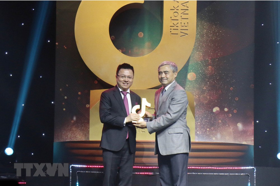  Le vice-directeur général de l’Agence vietnamienne d’Information (VNA) Le Quoc Minh (à gauche) reçoit le prix ''Community media channel of the year'' (Chaîne de médias communautaire de l’année), lors de la cérémonie de remise des Prix TikTok du Vietnam 2020, le 27 décembre à Ho Chi Minh-Ville.