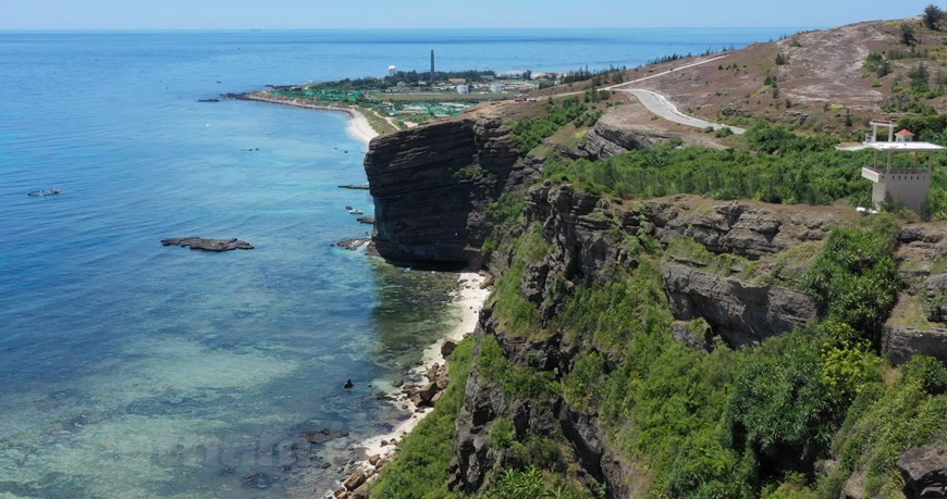  Peu de gens savent que l'île de Ly Son est une île volcanique. Avec ses magnifiques paysages laissés par ces volcans, l'île est devenue une destination séduisante pour les touristes. Vue de loin par une belle journée ensoleillée, l'île de Ly Son ressemble à une pyramide sur la mer. Au sommet de Thoi Loi, l’une des trois montagnes les plus hautes de Ly Son, les visiteurs auront une vue panoramique sur l’île, le phare de Ly Son, ses champs d'ail qui ressemble à un échiquier, ses villages de pêche..., où maisons, pagodes et végétation se fondent dans un tableau naturel. Photo : Vietnamplus 