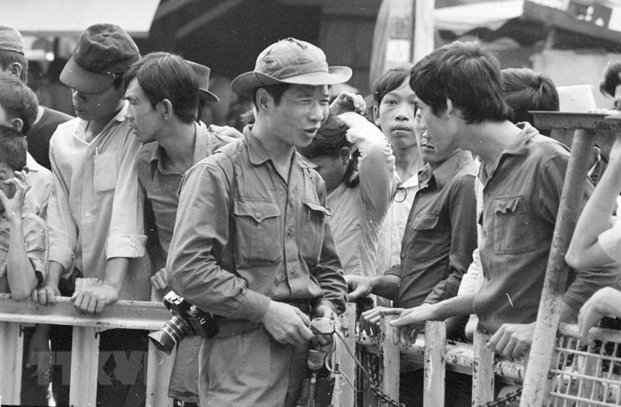  Le reporter Dinh Quang Thanh de l'Agence vietnamienne d’Information collecte des informations auprès des Saïgonnais le jour de la libération, le 30 avril 1975.