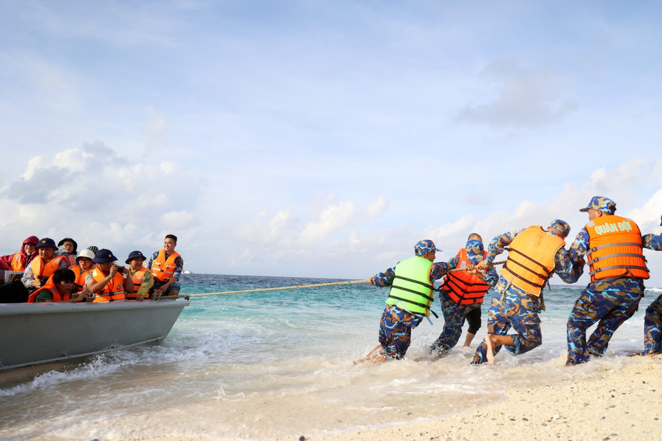 Les soldats tirent un canot sur l'île. Photo: VNA