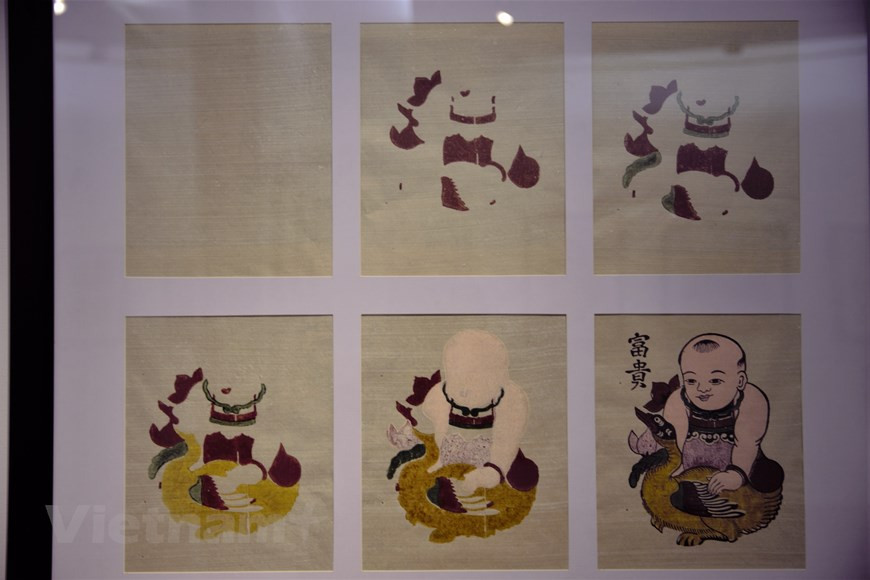  L’artisan doit utiliser plusieurs planches pour imprimer un tableau. Photo: Vi Dieu/Vietnamplus