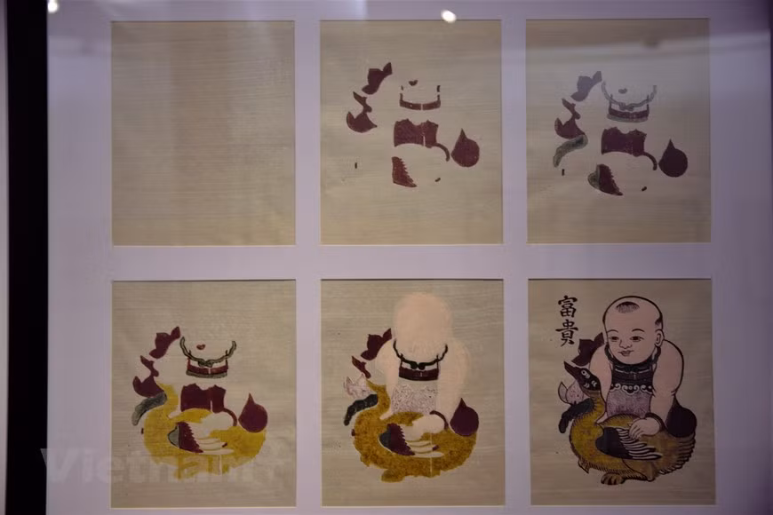  L’artisan doit utiliser plusieurs planches pour imprimer un tableau. Photo: Vi Dieu/Vietnamplus 