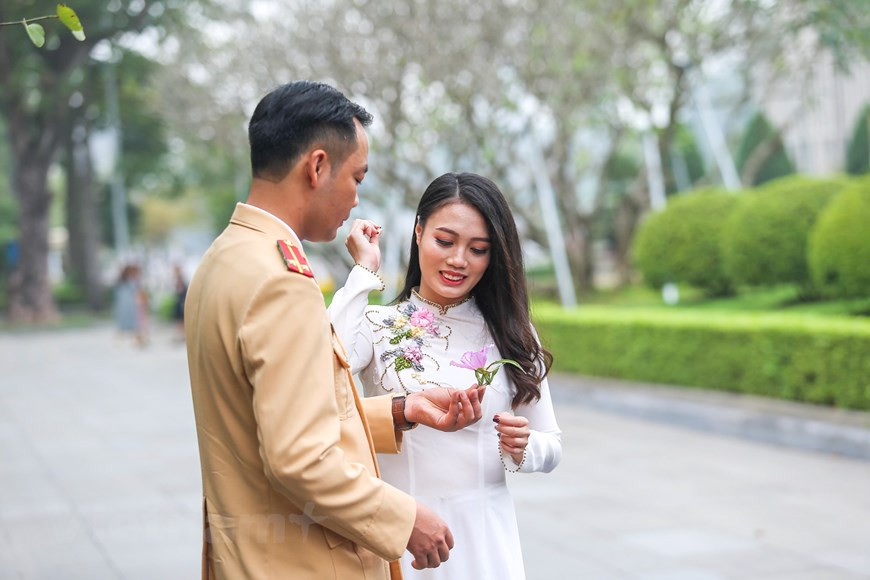  Un couple prend des photos avec des fleurs de bauhinie. Photo: The Dai/Vietnamplus