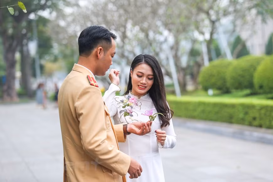  Un couple prend des photos avec des fleurs de bauhinie. Photo: The Dai/Vietnamplus 