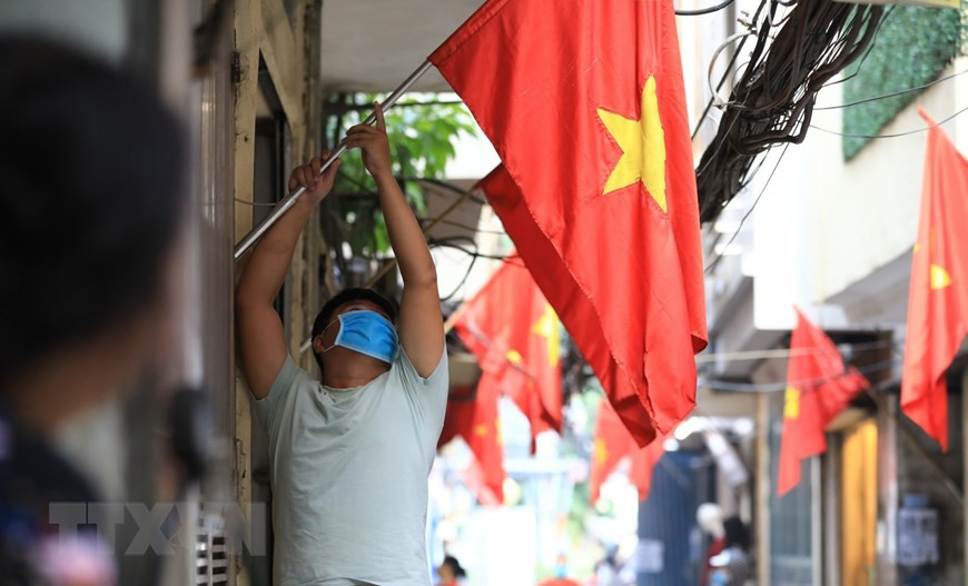 Pour célébrer la Fête nationale, des drapeaux flottent à chaque porte. Photo: VNA