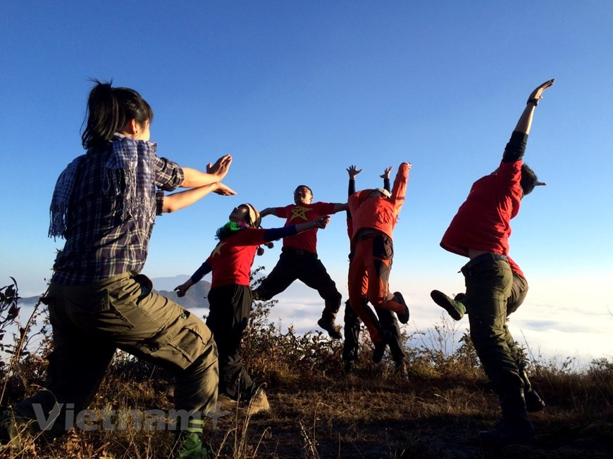 Un groupe de passionnés de trekking prend des photos sur le sommet Ky Quan San après un voyage difficile. Les grimpeurs ont dit à cause de la brume dense sur le sommet, il leur est donc un peu difficile de capturer les meilleures photos. La beauté majestueuse de la nature excite les jeunes. La montagne est très rocheuse et précipitée, celui qui a peur des hauteurs ne devrait pas essayer de marcher. Cependant, c'est un top idéal pour ceux qui veulent se remettre en question. Se réveiller tôt dans un endroit élevé pour regarder les premiers rayons de soleil et prendre des photos impressionnantes sont les plaisirs de nombreuses personnes. Photo: Vietnam+