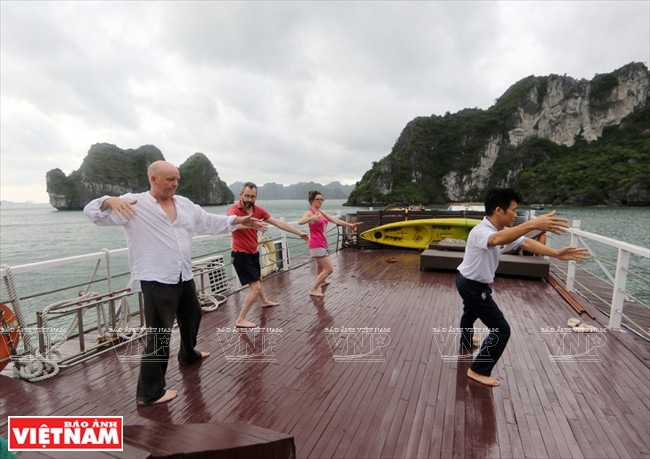 Des touristes font du yoga sur le bateau de bon matin. 