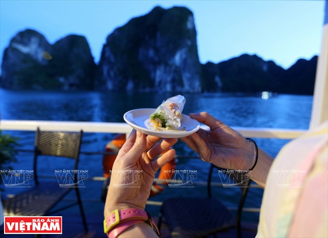 Le cuisinier du bateau An Nam apprend aux touristes à faire des nem (rouleaux de printemps).
