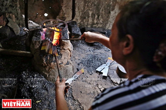 Des pièces de fer sont mises dans la forge.