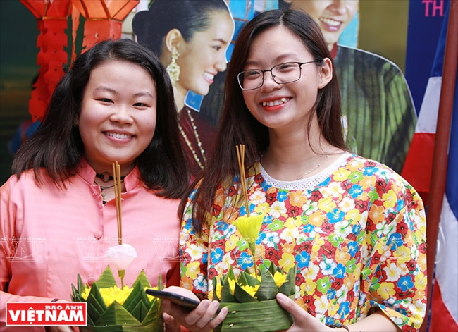 Des jeunes heureuses de faire une photo avec des lanternes de la fête Loy Kratong.