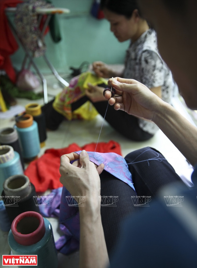 Pour que les pans soient souples, les tailleurs de Trach Xa brodent à la main les motifs de décoration. 