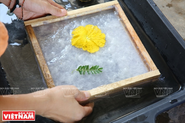 Un papier décoré d’une fleur jaune.