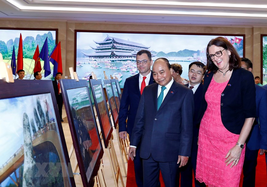 Le Premier ministre Nguyên Xuân Phuc, le ministre roumain de l’Environnement des affaires, du Commerce et de l'Entrepreneuriat Stefan Radu Oprea et La commissaire européenne au commerce Cécilia Malmström lors d'une exposition de photos tenue par la VNA.