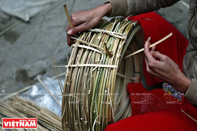 Les tiges de bambou sont coupées dans le sens de la longueur pour faire l’armature.