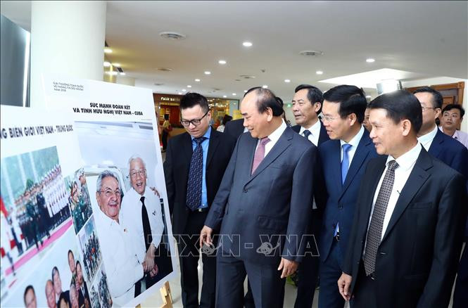 Le Premier ministre Nguyên Xuân Phuc et les délégués voient les photos recompensées. Photo: VNA