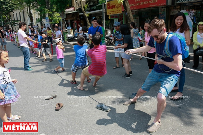 Un étranger participe à une partie de tir à la corde avec des enfants.