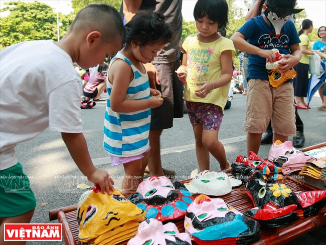 Les enfants aiment les masques en papier fabriqués par le club My Hanoï. 