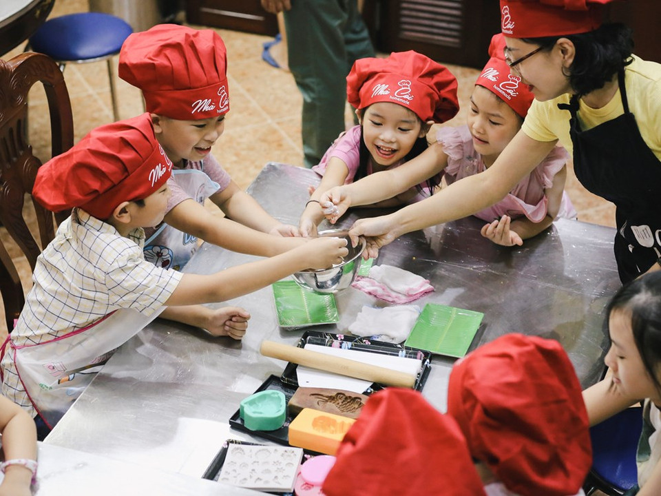 Les parents emmènent leurs enfants aux ateliers de fabrication de gâteaux de lune pour les sensibiliser à la signification de ces plats spéciaux et de la Fête de la Mi-automne.