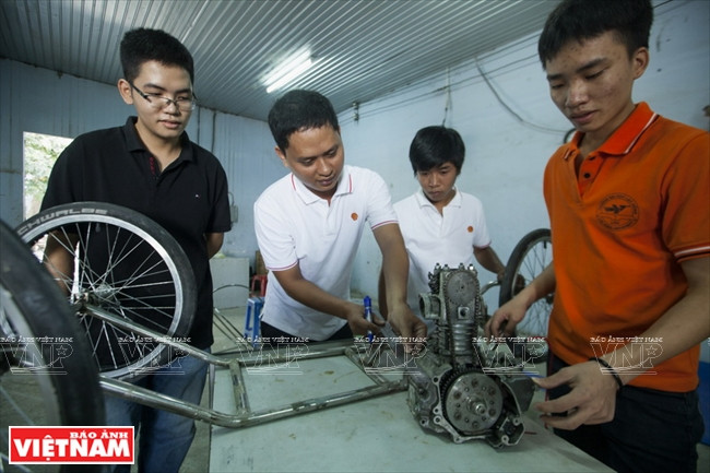 Les membres de l'équipe règlent le moteur pour répondre aux critères du concours.
