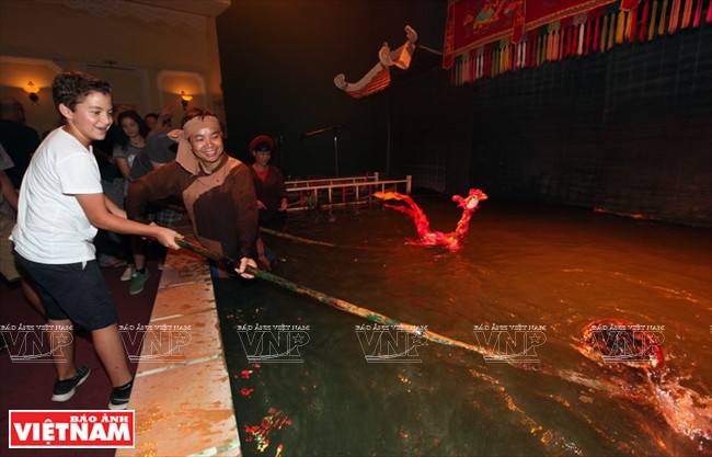 Un jeune spectateur apprenant à manipuler la marionnette. ​