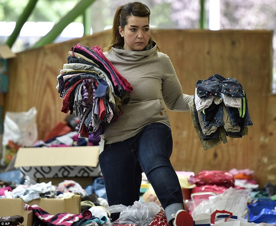 Une bénévole trie les vêtements pour enfants donnés par des habitants de Dortmund, en Allemagne. 