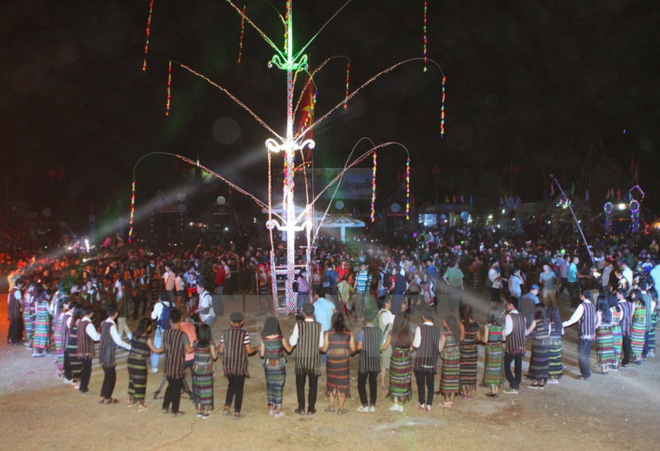 Les habitants locaux dansent autour d'un Cây nêu (perche rituelle du Têt).