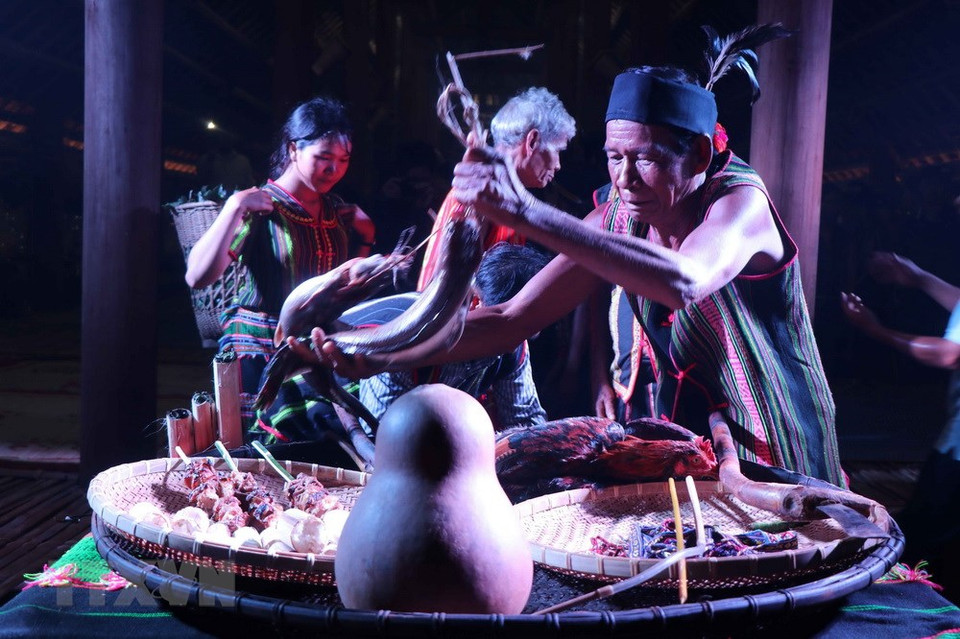 Le chef du hameau de Dak R'Moan met des offrandes sur l'autel.
