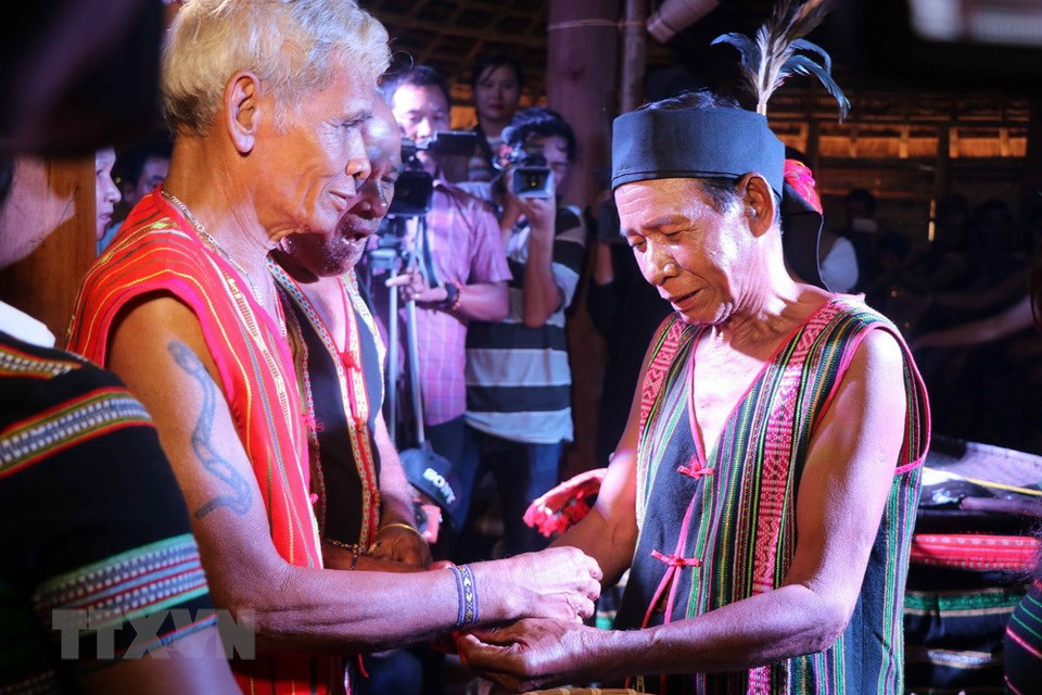 Le propriétaire de la maison offert un bracelet de santé à un visiteur après la cérémonie.