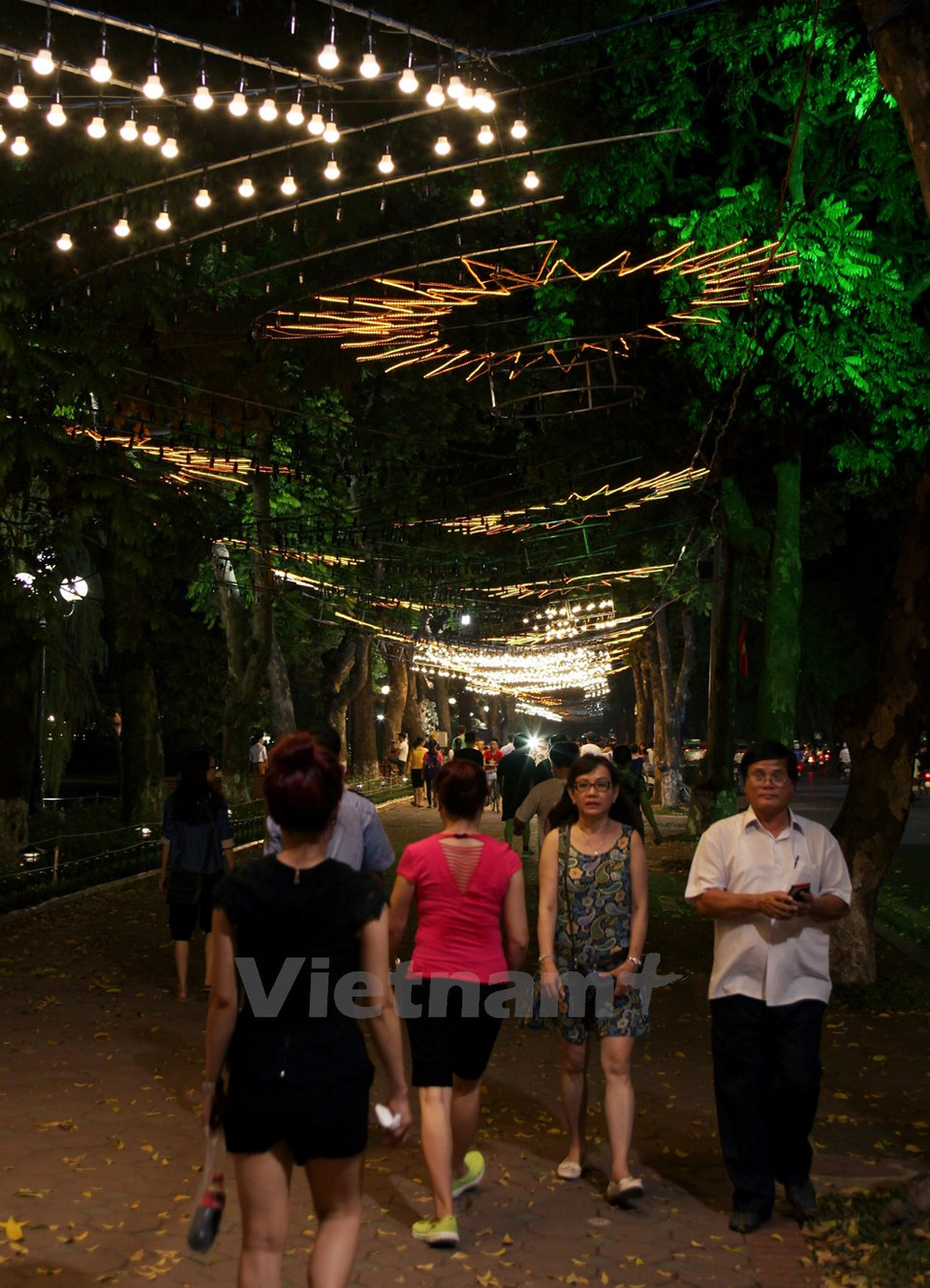 Des gens se promènent dans une "rue de lumière".