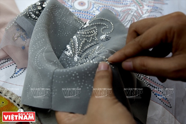 Pose des perles à la main.