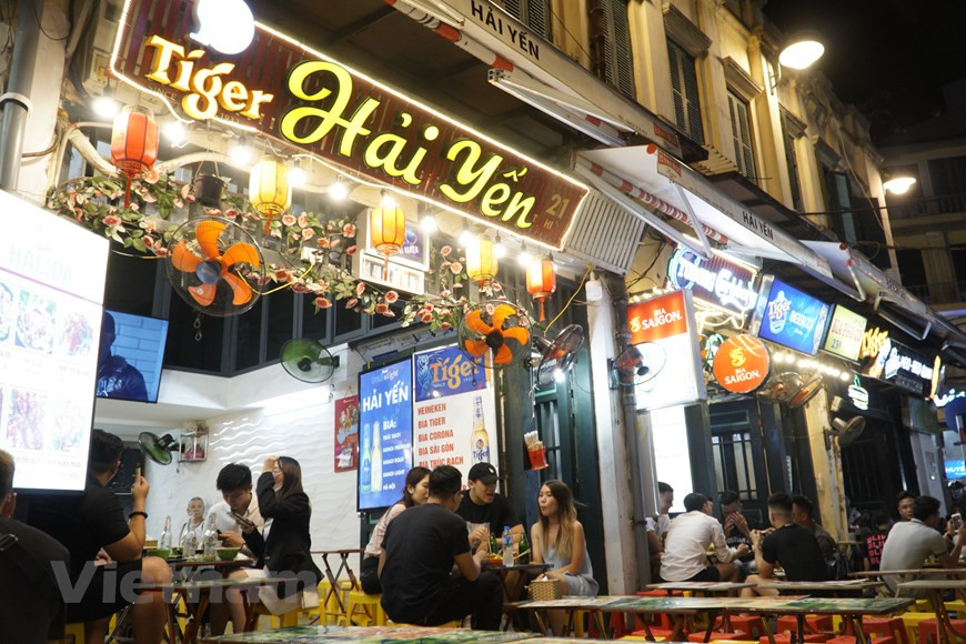 Tandis que la rue piétonnière Bùi Viên à Hô Chi Minh-Ville, surnommée "rue des Occidentaux", est réputée pour l’agitation, dans la rue Ta Hiên, se retrouvent chaque soir des jeunesses cosmopolites désireuses de découvrir le mode de vie local, mais aussi des Vietnamiens venus passer une bonne soirée entre amis. Il semble que le désaccord linguistique n’est qu’une mince affaire, tout le monde rit joyeusement. Un simple, discret, non-somptueux magasins de bière qui peuvent occuper une place particulière dans le cœur des invités ici. Ta Hiên - Ma Mây - Luong Ngoc Quyên est le "carrefour cosmopolite" avec de nombreux types de services, de lieux de restauration et de divertissements. Photo : VietnamPlus 