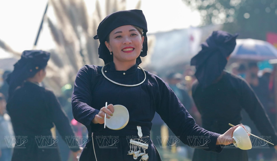 Des gens de l'ethnie Tay interprète une danse avec des bols lors d'un marché tenu au Village culturel et touristique des ethnies du Vietnam. 