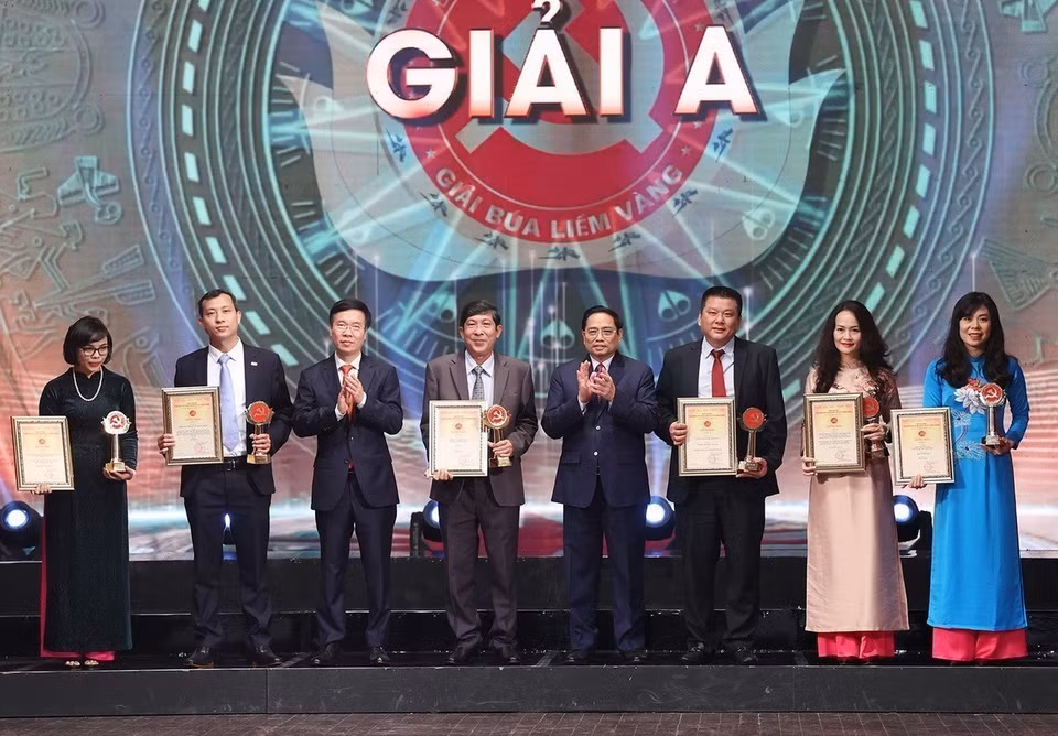 Le Premier ministre Pham Minh Chinh et le permanent du Secrétariat du Comité central du Parti Vo Van Thuong remettent le prix A de la 6e édition du Prix national sur l’édification du Parti, appelé « Bua liêm vàng » (Marteau et Faucille d’or) 2021. Photo : VNA